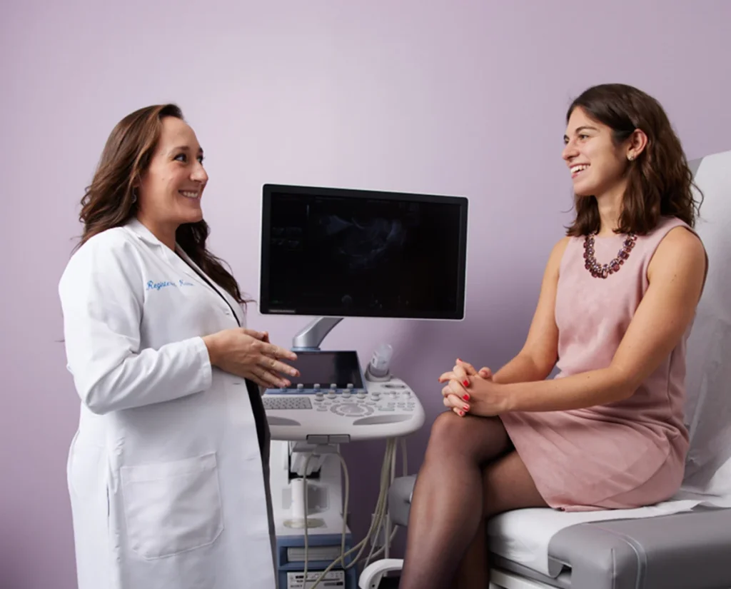 doctor discussing treatment with a patient in a medical office, featuring an ultrasound machine in the background